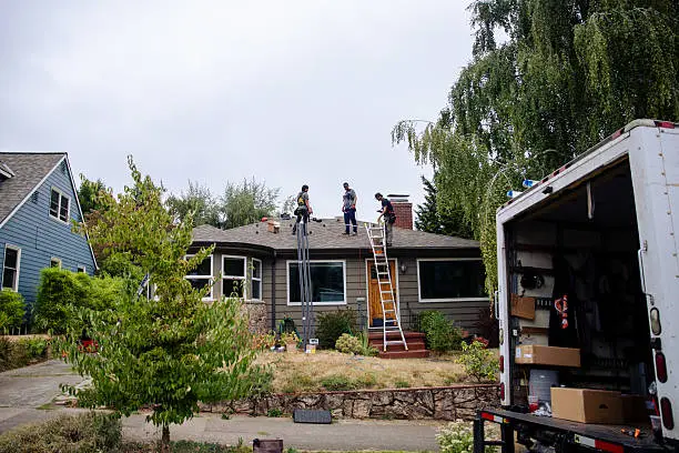 Storm Damage Roof Repair Washington NC 7 Roofing crew on a home’s roof with ladders and an equipment truck in Washington, NC