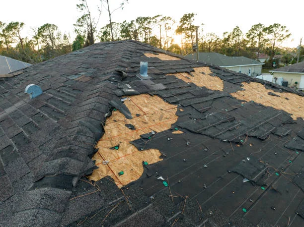 Roof Repair Washington NC 5 Storm-damaged roof with shingles torn off, exposing underlayment and wood decking